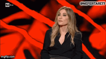 a woman in a black shirt is sitting in front of a red background with the hashtag nefertari77 on it
