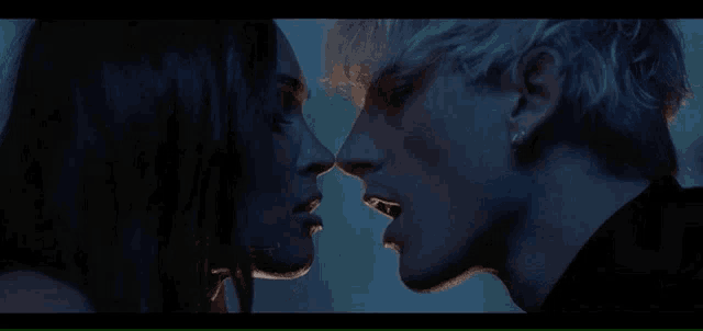 a close up of a man and a woman kissing in the dark .