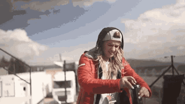 a woman wearing a red jacket and a white hat with the word motul on it