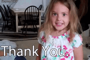 a little girl in a floral dress is smiling and says thank you .