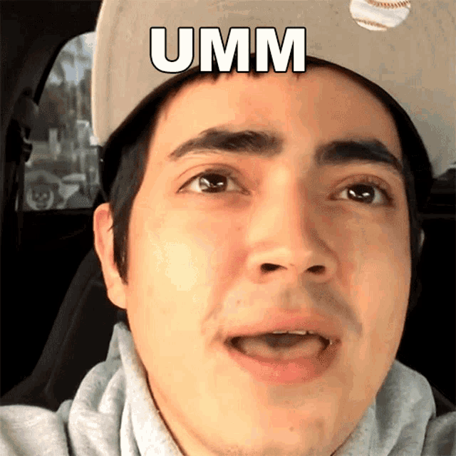 a man wearing a baseball cap has the word umm on his head