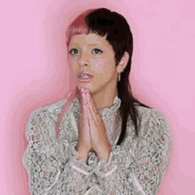 a woman with pink hair is wearing a white lace top