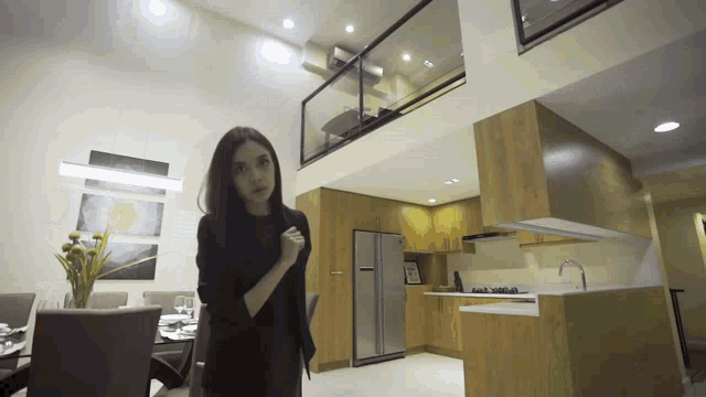 a woman stands in a kitchen with a lg refrigerator