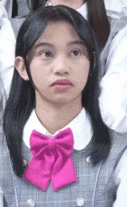 a girl with long hair and a pink bow tie