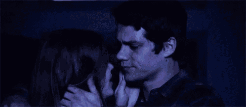 a man and a woman are kissing in the dark in a dark room .