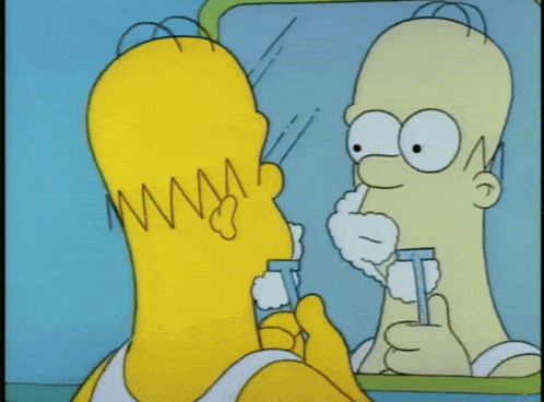 homer simpson is looking at his reflection in the mirror