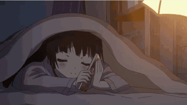 a girl is reading a book under a blanket and smiling
