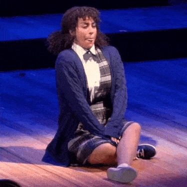 a woman is sitting on the floor with her legs crossed