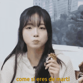 a girl is eating a piece of cake and the words come si eres de marti are visible