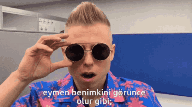 a man wearing sunglasses says eymen benimkini görünüce olur gibi