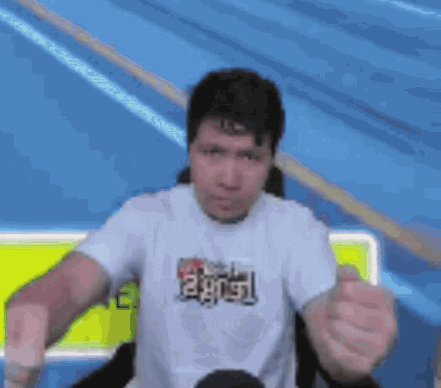a man wearing a white t-shirt that says ' riot ' on it is giving a fist bump