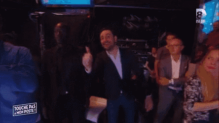 a man in a suit is standing in front of a crowd and a sign that says touche pas mon poste