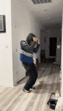 a man wearing a blue vest that says ' emergency ' on it