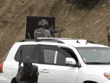 a man in a gign vest is standing in front of a white suv
