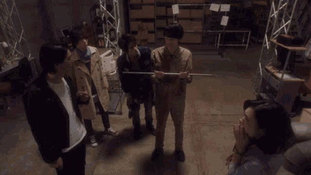 a group of people are standing around a man on the ground