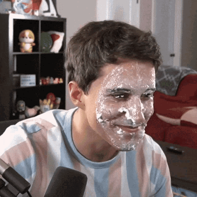 a man with frosting on his face looks at the camera