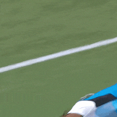 a man in a blue shirt and white shorts is playing soccer on a field