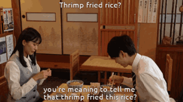 a man and a woman are sitting at a table with shrimp fried rice