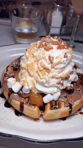 a waffle with whipped cream and pecans on it