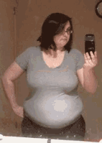 a woman taking a picture of herself in a bathroom mirror