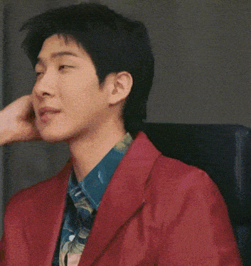 a close up of a person touching a man 's face while he is wearing a red jacket .