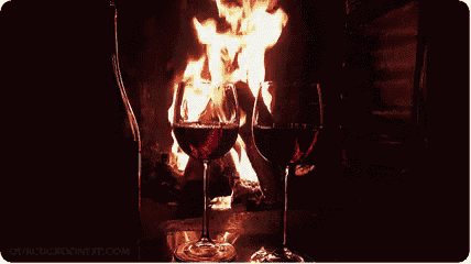 two glasses of wine in front of a fireplace