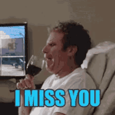 a man sitting in a chair drinking a glass of wine with the words i miss you on the bottom