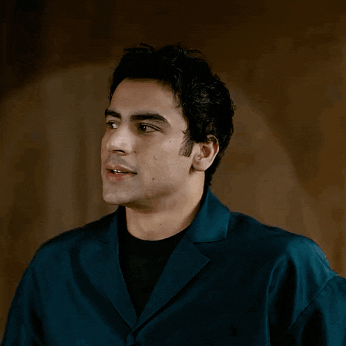 a man in a blue shirt and black shirt is smiling