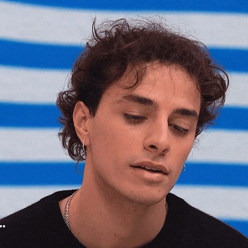 a close up of a man 's face against a blue and white striped background