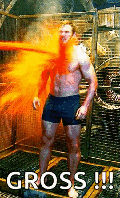 a man without a shirt is standing in a cage with fire coming out of his mouth and a caption that says gross !!!