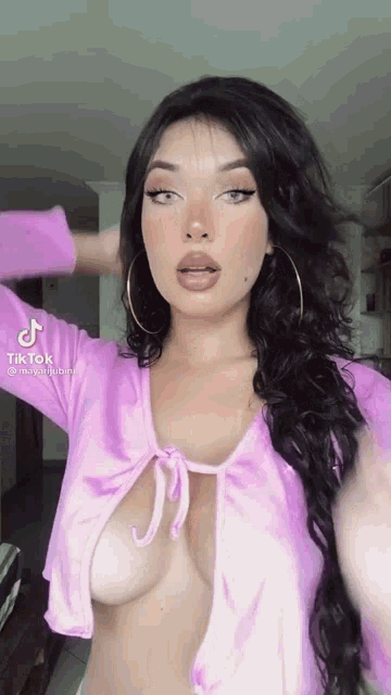 a woman is wearing a purple top with a very low cut neckline