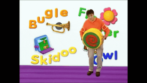 a man is holding a colorful object in front of a wall that says bugle