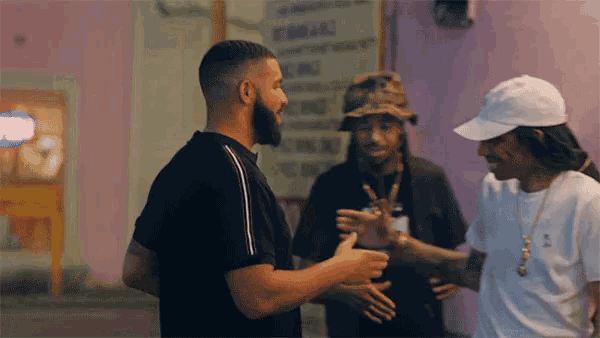 a man in a black shirt is talking to two other men in white hats