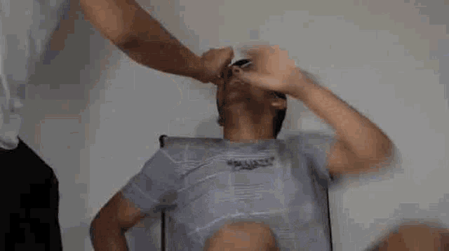 a man is being punched in the face by another man in a room .