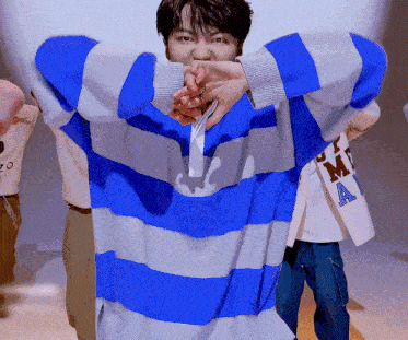 a man wearing a blue and white striped sweater with the letter a on his jacket