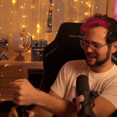 a man with pink hair is sitting in a dxr racer chair