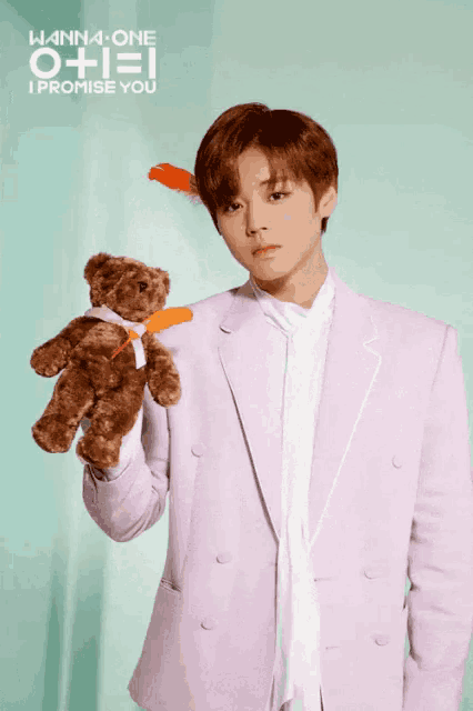 a man in a purple suit is holding a teddy bear with the words wanna one i promise you written above him