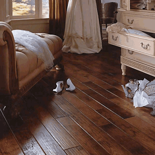 a room with a couch and a dresser with a wedding dress on the wall