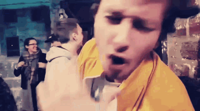 a man in a yellow shirt is making a face