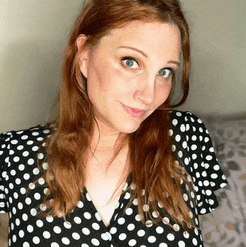 a woman is wearing a black and white polka dot dress