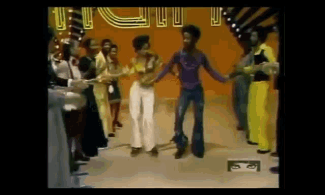 a group of people are dancing in front of a sign that says ' i 'm a fool '