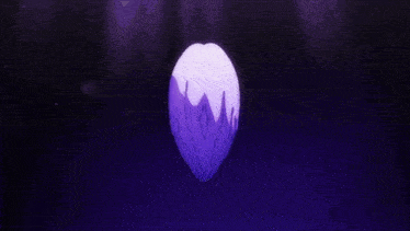 a person 's hands are holding a purple object in a dark room