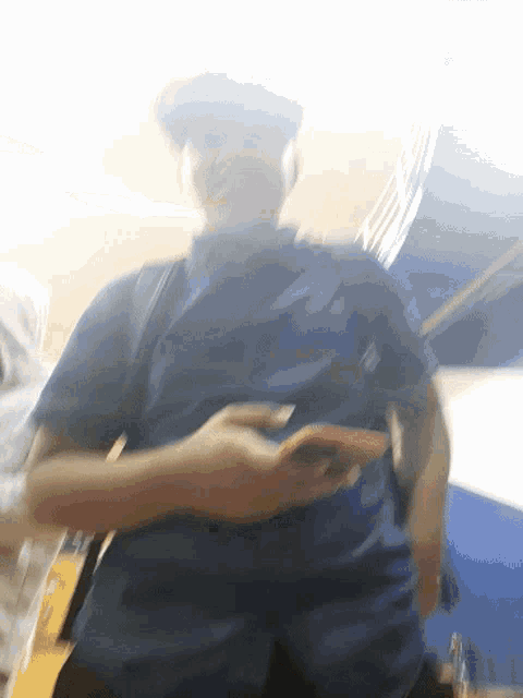 a man in a blue shirt is holding a cell phone
