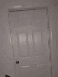 a person is standing in a room with a white door open .