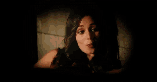 a close up of a woman 's face with her eyes closed in a dark room .