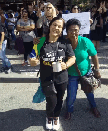 two women posing for a picture with one wearing a shirt that says " não corrupto "