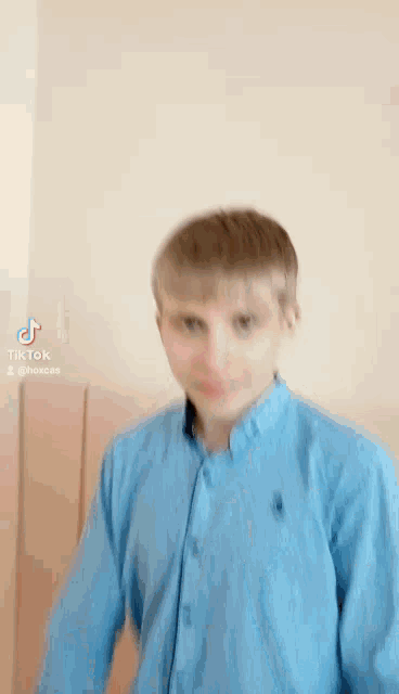a young boy is wearing a blue shirt and smiling .