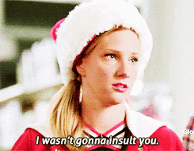 a woman wearing a santa hat says " i wasn 't gonna insult you "