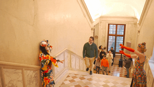 a man in a green sweater is walking down the stairs