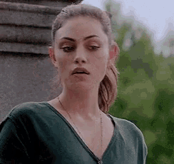 a woman with a ponytail is wearing a green shirt